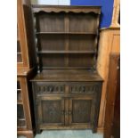 A dark oak dresser with plate rack above and cupboard below (H174cm W91cm D43cm)