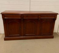 A Waring and Gillow style cherry wood three door reproduction sideboard (H90cm W166cm D47cm)
