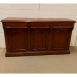 A Waring and Gillow style cherry wood three door reproduction sideboard (H90cm W166cm D47cm)