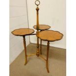 A Three tier cake stand on fluted and down swept legs, each stand decorated with hand painted