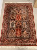 A red ground rug with centre squares (140cm x 215cm)