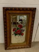 A screen printed mirror set in a mahogany frame