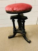 An ebonized and gilt revolving piano/music stool