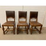 Three matching oak leather seated chairs with ring turned legs.