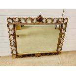 A Giltwood composition mirror with rectangular plate and scrolling border. (104 cm x 90 cm)
