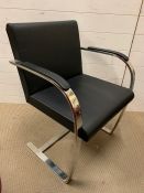 A contemporary desk chair with chrome frame and leather seat and back