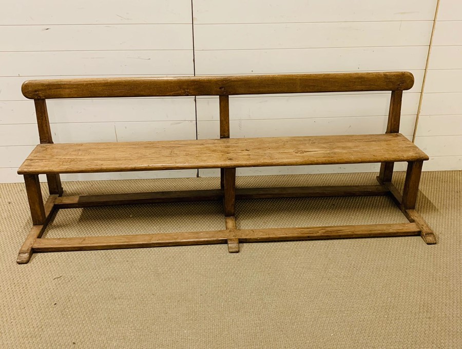 A Victorian pine school pew (H64cm W190cm D63cm)