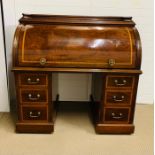 A mahogany cylinder front desk, opening to reveal a fitted interior, the drawers with turned