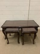 A mahogany set of coffee tables with glazed tops