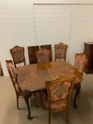 An extending dining table with moulded top on pad feet, two leaves and six upholstered chairs (Table