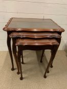 A nest of three tables with glass tops