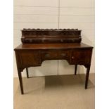 A Regency style mahogany dressing table / desk. Central drawer and arched kneehole flanked by deep