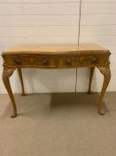 A writing desk with two drawers to centre on carved and scrolled cabriole legs