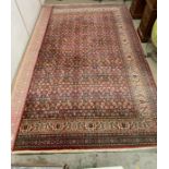 A red ground rug with centre square and boarder (353cm x 250cm)