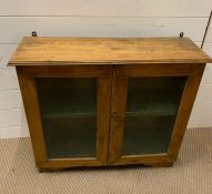 A antique pine wall hanging display case with two glazed doors to front (H67cm W74cm D23cm)