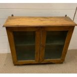 A antique pine wall hanging display case with two glazed doors to front (H67cm W74cm D23cm)