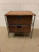 A wicker two door chest on metal frame