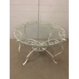 A wrought iron, glass topped table (91 cm Diameter x 54 cm high)