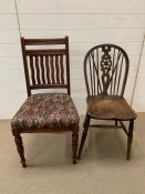 One oak wheelback chair and one oak dining chair