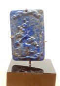 A Chinese lapis lazuli in form of a tablet, carved in shallow relief with a landscape, pierced for