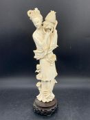 A carved Japanese lady on stand