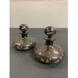 A pair of white metal overlay perfume bottles