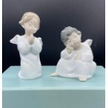 A boxed set of Lladro, Two angels. One sitting and one kneeing praying.