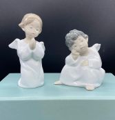 A boxed set of Lladro, Two angels. One sitting and one kneeing praying.