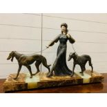 An Art Deco sculpture of a Lady walking two dogs in bronze, with ivorine hands and face. (Face is in
