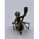 A Silver figure of an angel playing a lyre.