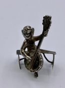 A Silver figure of an angel playing a lyre.