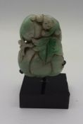 A Chinese carved whitish/green jade in form of a gourd fruit and a monkey, pierced for