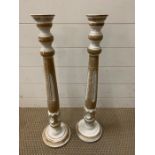 A pair of tall painted candlesticks