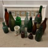 A selection of vintage beer bottles and others along with a framed vintage advertising clippings and