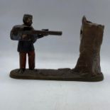 A Vintage cast iron moneybox in the form of a marksman and target.
