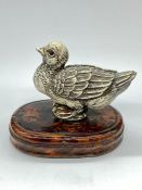 An Antique ivory bird on a wooden base.