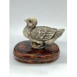 An Antique ivory bird on a wooden base.