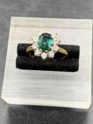 An Emerald and Diamond ring on an 18ct yellow gold setting, central emerald with ten diamonds