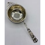 A Silver tea strainer, by CE Williams , marked Birmingham 1912.