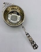 A Silver tea strainer, by CE Williams , marked Birmingham 1912.