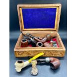 A selection of vintage smoking pipes various makers to include Peterson in a carved wooden box