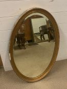 An oval gilt framed mirror (82 cm x 52 cm)