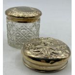 A silver lidded glass jar and a silver lid.