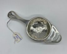 A silver tea strainer, hallmarked for Birmingham 1931 by William Adams ltd