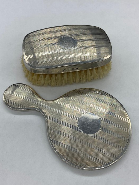 A Hallmarked silver backed hand mirror and brush