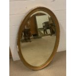 An oval gilt framed mirror (82 cm x 52 cm)