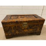 A carved oriental chest with brass lock to front (H48cm W70cm D34cm)