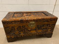 A carved oriental chest with brass lock to front (H48cm W70cm D34cm)