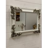 A wall hanging mirror with scroll details to corners (H60cm W80cm)
