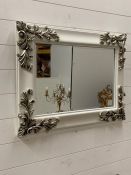 A wall hanging mirror with scroll details to corners (H60cm W80cm)